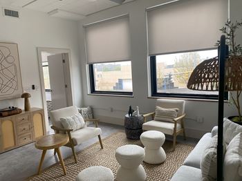 A living room with a white chair and ottoman.